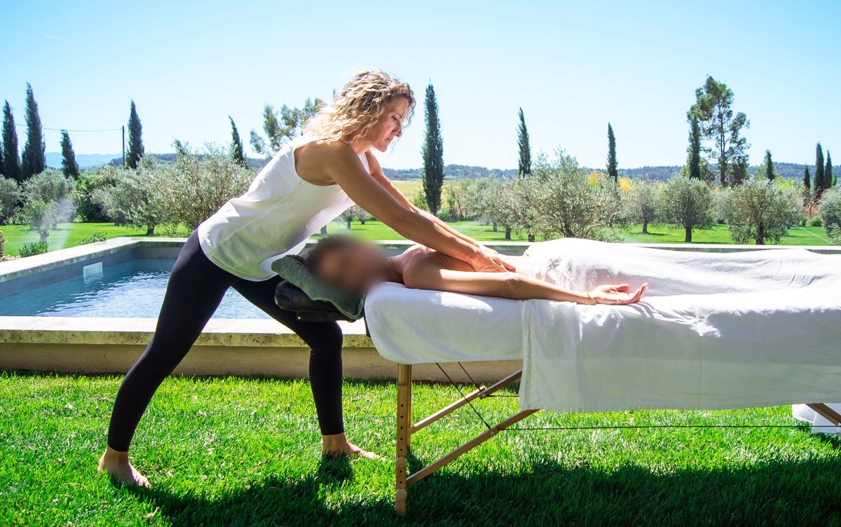 Christine Jullien giving an outdoor massage by the pool of a holiday home in the Luberon