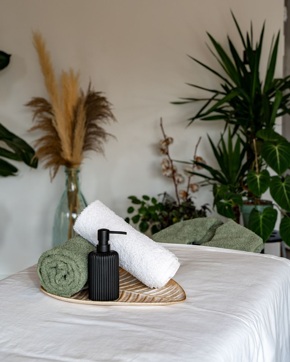 Table de massage dressée avec serviettes et huile, prête pour un massage offert en bon cadeau dans le Luberon